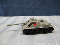 Side view of the vintage toy tank showing red star decal, number 100, and black tracked wheels detail