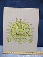 Front view of the artwork showing the full cap badge with details and signature.