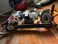 Echo CS346 chainsaw with blade bar, Makita grinder and double grinder side by side on wooden floor