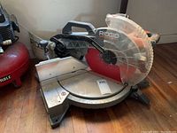 Full view of Ridgid sliding compound miter saw on hardwood floor