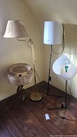Shows all four lamps and lamp shade together in corner of room with vintage style and condition.
