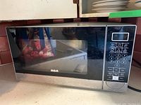 Front view of the RCA microwave showing the glass door and control panel keypad with digital display.