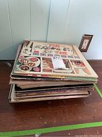 Stack of vinyl records on the floor with top album by The Mothers