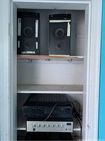 Two Castle Durham speakers on top shelf, a black SR-3 stereo receiver and silver Fanon Pro35 amplifier on lower shelf