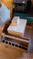 Photo showing wooden toolbox with handle and six compartments, alongside two smaller wooden storage boxes stacked on top of a larger wooden box.