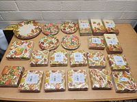 Front view of multiple packs of Thanksgiving-themed paper napkins and round plates arranged on a table, napkins sealed in original packaging.