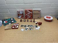 Full lot overview showing DVDs, Christmas ornaments, earrings, gift bags, figurines, and container.