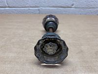 Top-down view of both glass door knobs showing the detail in the faceted clear glass and metal bases with patina.