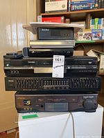 Full stack showing Toshiba DVD/VCR combo, TEAC equalizer, Hitachi VCR, and Sharp mixer.