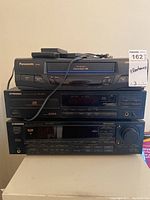 Front stacked view of Panasonic PV-9400 VCR, Pioneer PD-4550 CD player, and Pioneer VSX-4400 stereo receiver on beige surface.