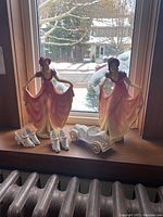 Full view of two Marbolex figurines and accessories placed on a windowsill, snow outside