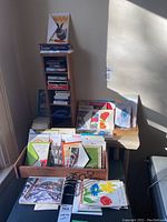 Photo of a corner with a wooden organizer holding boxes of playing cards and racks with various greeting cards arranged in trays.