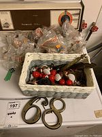Wide shot of wicker basket containing assorted knobs and hardware, placed on a washing machine.