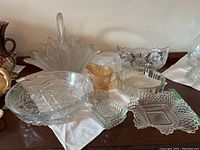 Collection of various pressed and leaded glassware on cloth-lined surface