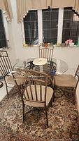Full view of square glass top table with four chairs in room