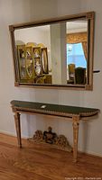 View of console table mounted to wall with matching mirror above in entryway