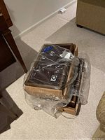 Two wooden Panasonic speakers packed in a box, covered with thin plastic bag, showing size and packaging condition