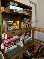 Shelf with stacked vintage board games and puzzles.