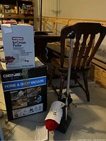 Photo showing Genie Jet Vac wet/dry vacuum boxed with visible attachments, Waring Ice Cream Parlor box nearby, and Dremel shoe polisher in foreground.