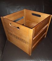 Wooden Victrola vinyl record box showing branding on the side and cutout handles on opposite sides for carrying