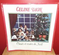 Front cover of Celine Dion's vinyl record album 'Chants et contes de Noël', showing the artist with children and a Christmas tree.