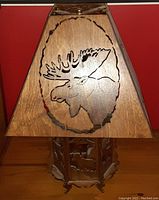 Trapezoidal wooden lamp shade with carved moose head in oval frame