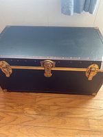 Closed black storage trunk with metal studs and locks.