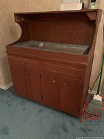 Full view of vintage wooden dry sink with metal insert basin, showing cabinet doors and drawers.