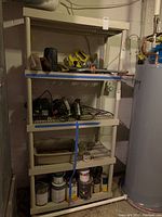 Front angle photo of beige plastic storage shelf with four slatted shelves, empty except for attached price tag. Shown in a basement environment.