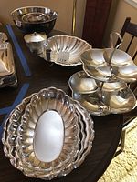 Photo of the silverplate serving pieces including platters, shrimp cocktail server, bowls, lidded serving dish, and two-tier cupcake tree