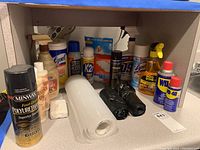 Lot items as seen on countertop with various cleaning sprays and liners in a kitchen environment
