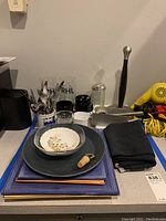 Overview of the plates, kitchenware, glasses, utensils, and accessories on a table.