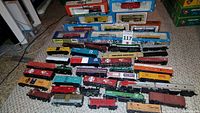 Loose HO scale rolling stock arranged on carpet