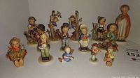 Group of Hummel figurines of children and animals in varied poses and sizes from 2 to 7 inches