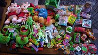 Lot showing assortment of plush toys including Miss Piggy and Kermit, Muppet PVC figures, keychains and small toys