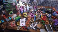 Wide overview of all figurines, trading cards, small toys including Funko Pop boxed figures, pixelated Minecraft style blocks and Roblox style figures, and other assorted collectibles.