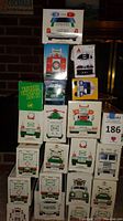 Stack of various Hess toy trucks in original boxes showing front and top box panels.
