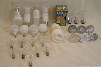 Photo showing arranged LED bulbs, chandelier bulbs, spiral CFL bulbs, and halogen spotlight bulbs.