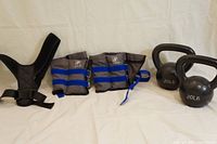 Photo of posture correcting strap, adjustable ankle/wrist weights, and York kettlebells arranged side by side