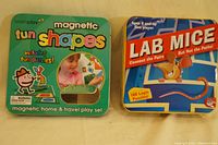 Two kids' games set side by side: Magnetic Fun Shapes by Learnplay and Lab Mice logic puzzles, in metal tins.