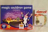 Box of Magic Cauldron educational board game and box of Slamwich card game shown together.