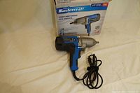 Full view of Mastercraft corded impact wrench with packaging box in background.
