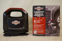 Motomaster air compressor with original box showing product branding and some usage info.