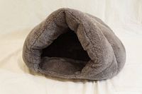 Front view of the small gray plush pet bed showing the cave-like entrance for a small dog or cat.