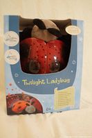 Twilight Ladybug night projector in original box with product and branding info visible. Product designed for infants, projects starry night sky in three colors.