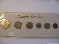 Six 1971 Canadian coins arranged from Penny to Silver Dollar in plastic sleeve marked 'Canada Year Set'.