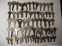 Full view of 66 assorted old keys arranged in rows showing differences in shape, size, and head design.