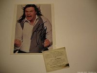 Signed Meat Loaf photo with certificate of authenticity placed at bottom right, showing slight charring at edges of photo