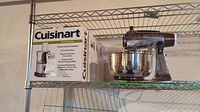 Photo of boxed Cuisinart 8-Cup Food Processor on metal shelf with the vintage Sunbeam mixer behind it.