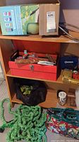 Wide shelf showing toolbox, garden sprayer, hose, drills, and cabinet pulls.
